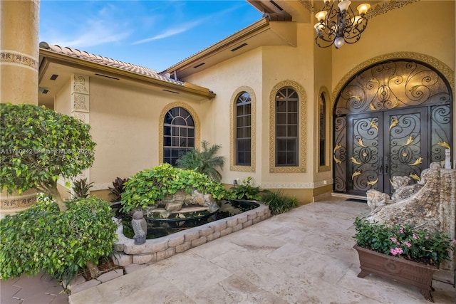 doorway to property featuring a tiled roof and stucco siding