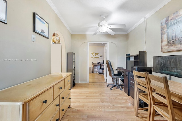 office area featuring arched walkways, light wood-style flooring, crown molding, and ceiling fan