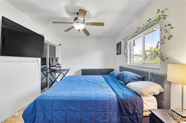 bedroom featuring a textured ceiling, wood finished floors, and a ceiling fan