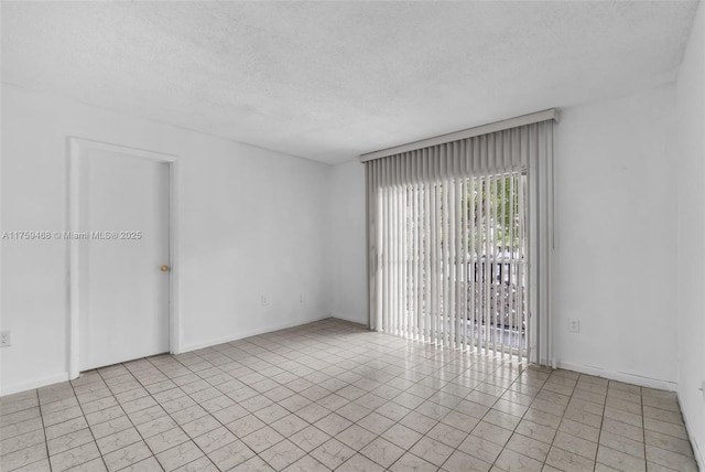 empty room with a textured ceiling and baseboards