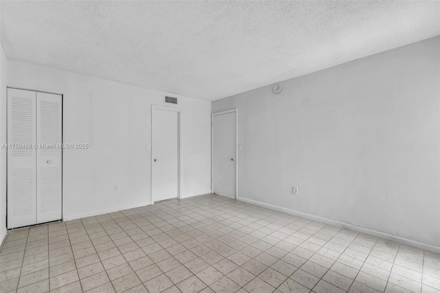 unfurnished bedroom with visible vents, baseboards, and a textured ceiling