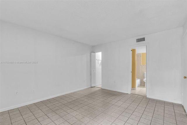 unfurnished room with visible vents and baseboards