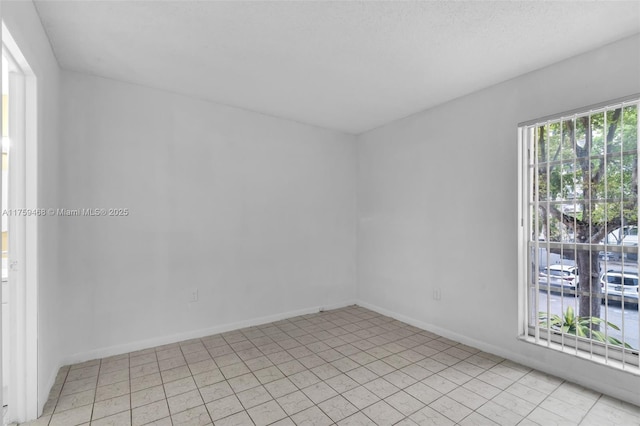 unfurnished room with baseboards