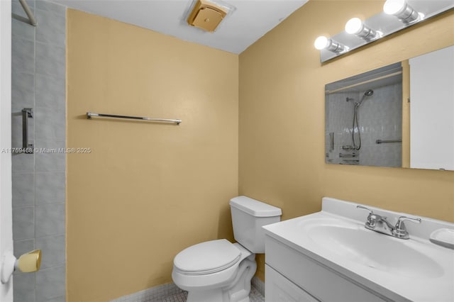 bathroom featuring vanity, toilet, and tiled shower