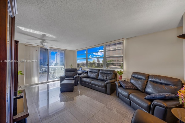 living area with expansive windows, a textured ceiling, and a ceiling fan