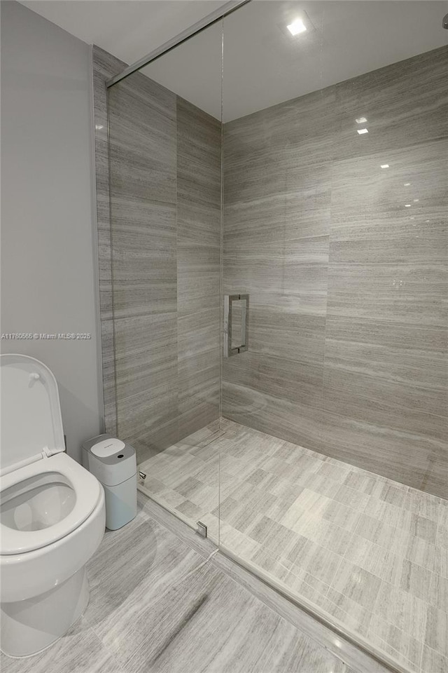 full bathroom featuring a stall shower and toilet