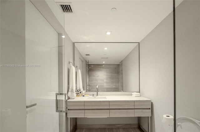 bathroom featuring vanity, a shower stall, recessed lighting, and visible vents