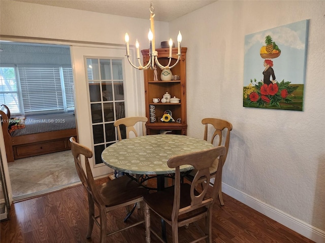 dining room with baseboards, an inviting chandelier, and wood finished floors