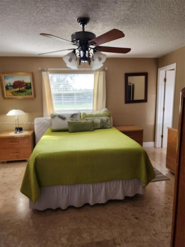 bedroom with a textured ceiling and a ceiling fan