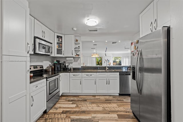 kitchen featuring visible vents, a sink, open shelves, appliances with stainless steel finishes, and white cabinets