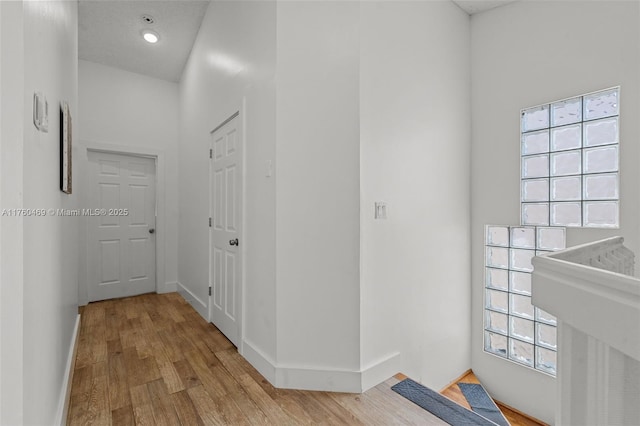 hallway with a sink, baseboards, and wood finished floors