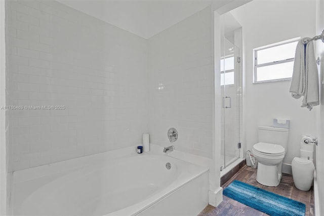 bathroom with wood finished floors, toilet, a bath, and a stall shower