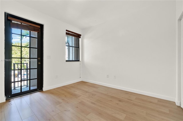 unfurnished room featuring baseboards and light wood-type flooring