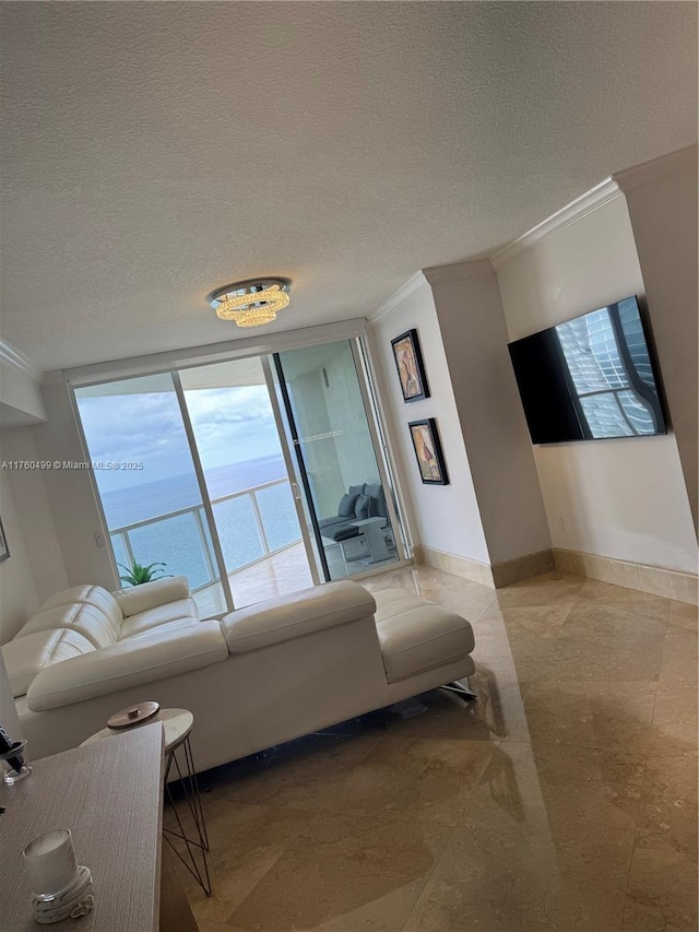 living area with a textured ceiling, baseboards, and ornamental molding