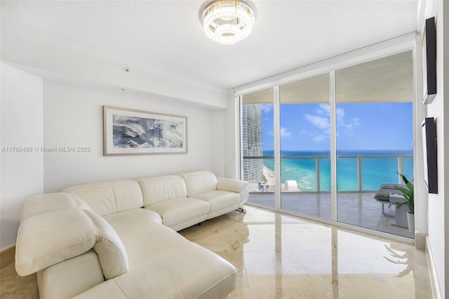 living room with floor to ceiling windows, marble finish floor, and a water view