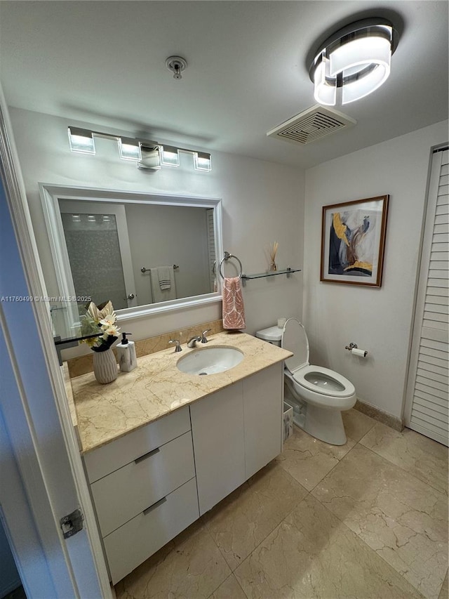 bathroom featuring visible vents, toilet, vanity, and baseboards