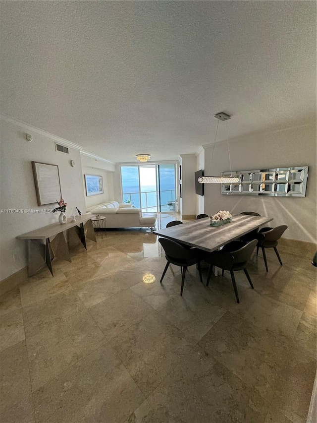 dining room with visible vents, a textured ceiling, and crown molding