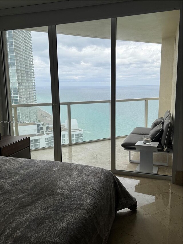 bedroom featuring a water view and floor to ceiling windows