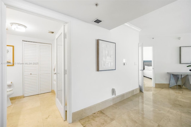hall featuring baseboards, visible vents, and marble finish floor