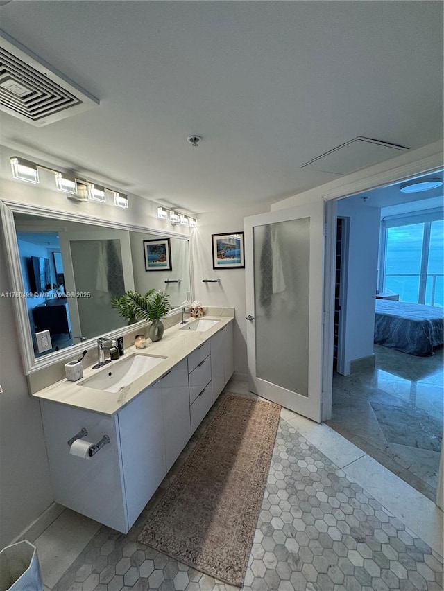 full bath featuring double vanity, visible vents, ensuite bathroom, and a sink