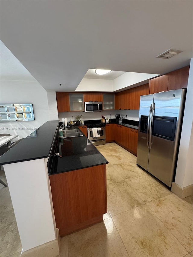 kitchen featuring dark countertops, visible vents, stainless steel appliances, and glass insert cabinets