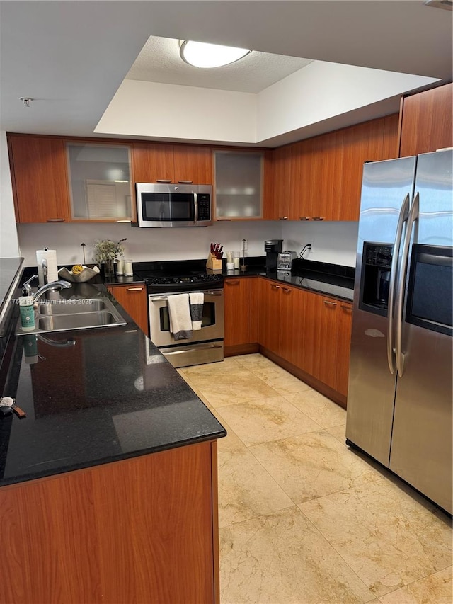 kitchen with a sink, appliances with stainless steel finishes, and brown cabinetry