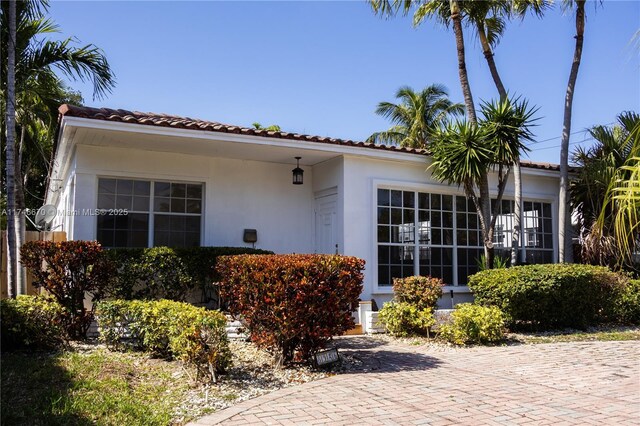 8926 Dickens Ave, Surfside, FL 33154 - view of front of home with a tiled roof and stucco siding