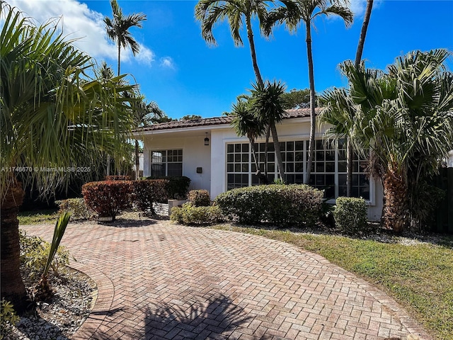 view of front of property featuring a tiled roof and stucco siding