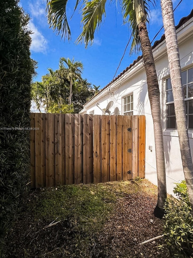 view of property exterior with stucco siding and fence