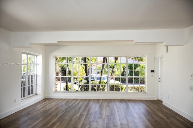 empty room with dark wood-style floors and baseboards