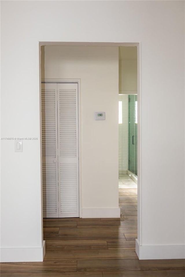 hallway with baseboards and wood finished floors