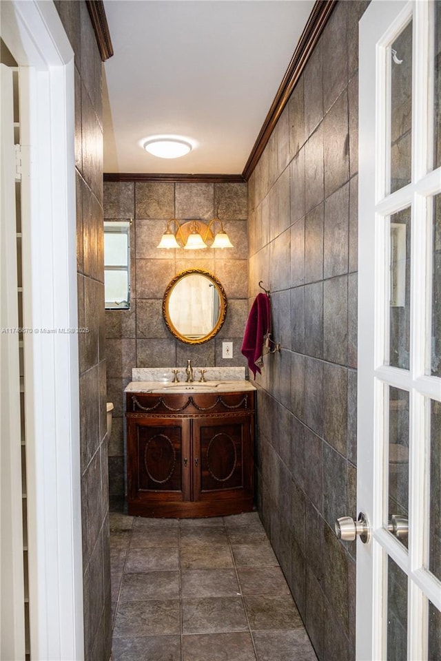 bathroom featuring vanity, tile walls, tile patterned flooring, and ornamental molding