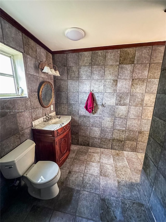 bathroom featuring toilet, tile walls, and vanity