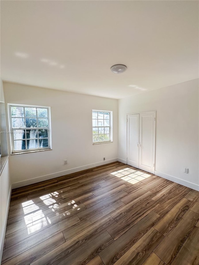 empty room with baseboards and wood finished floors