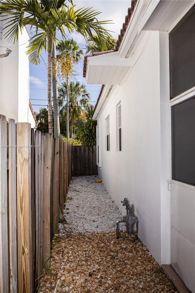 view of property exterior with stucco siding and fence