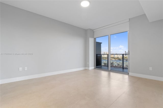 unfurnished room featuring baseboards and concrete flooring