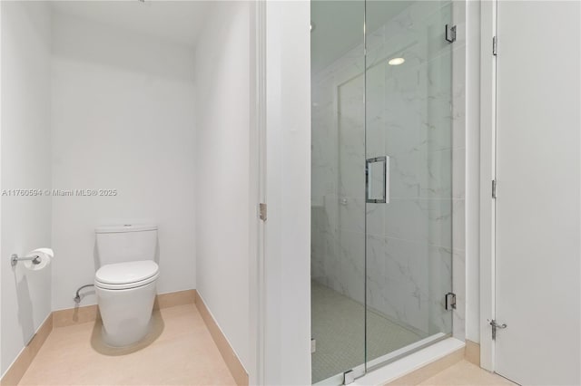 bathroom with a marble finish shower, toilet, and tile patterned flooring