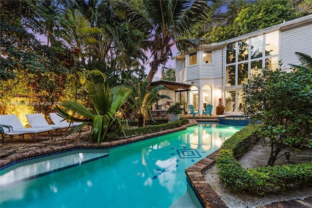 view of swimming pool featuring a pool with connected hot tub and a patio area