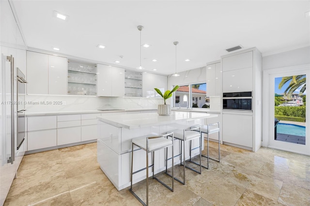 1117 Bella Vista Ave, Coral Gables, FL 33156 - kitchen featuring open shelves, a kitchen breakfast bar, white cabinetry, and modern cabinets