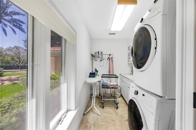 1117 Bella Vista Ave, Coral Gables, FL 33156 - laundry room featuring visible vents, stacked washer / dryer, and cabinet space