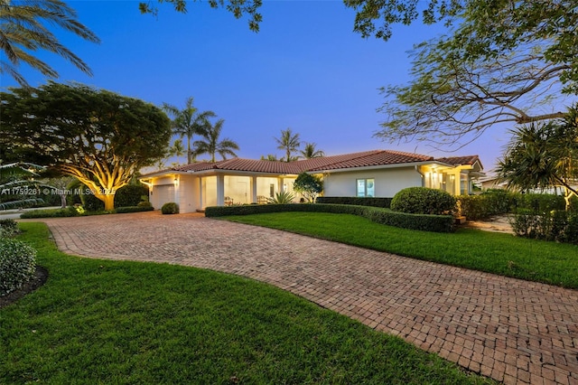 1117 Bella Vista Ave, Coral Gables, FL 33156 - view of front facade featuring stucco siding, a front yard, a tiled roof, and curved driveway