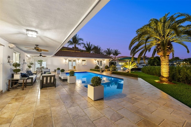 1117 Bella Vista Ave, Coral Gables, FL 33156 - pool at dusk featuring a patio area, outdoor lounge area, an outdoor pool, a ceiling fan, and french doors