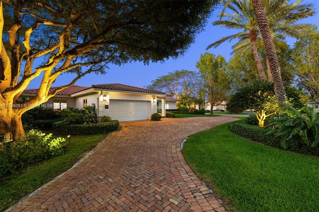 1117 Bella Vista Ave, Coral Gables, FL 33156 - view of front of home with a tiled roof, an attached garage, a front yard, stucco siding, and decorative driveway