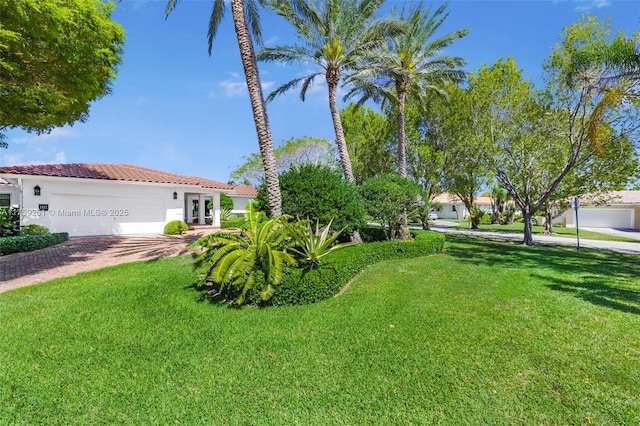 1117 Bella Vista Ave, Coral Gables, FL 33156 - view of front facade featuring stucco siding, a tile roof, driveway, a front yard, and a garage