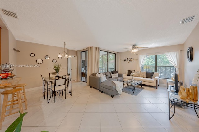 2888 S Carambola Cir S Unit 2079, Coconut Creek, FL 33066 - living area featuring a ceiling fan, a chandelier, and light tile patterned floors