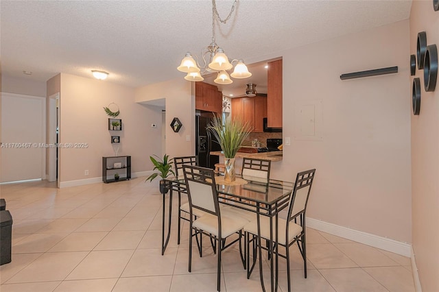 dining space featuring light tile patterned floors, a textured ceiling, and baseboards