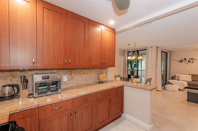 kitchen featuring backsplash, light tile patterned flooring, and brown cabinetry