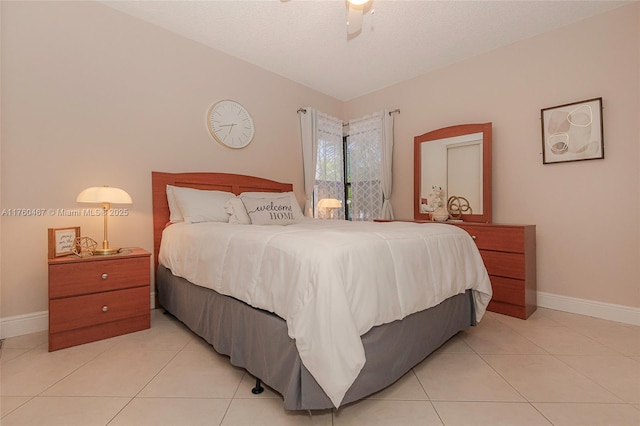 bedroom with lofted ceiling, light tile patterned floors, baseboards, and a textured ceiling