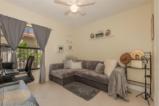 living room featuring light tile patterned flooring, baseboards, a textured ceiling, and a ceiling fan