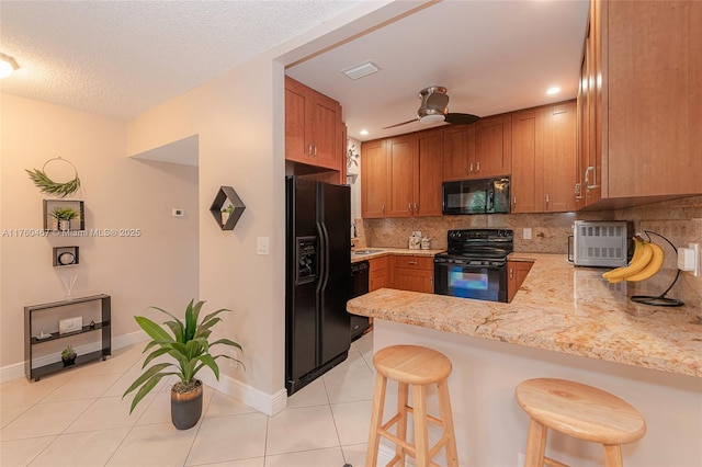 2888 S Carambola Cir S Unit 2079, Coconut Creek, FL 33066 - kitchen featuring black appliances, light tile patterned floors, tasteful backsplash, a peninsula, and ceiling fan